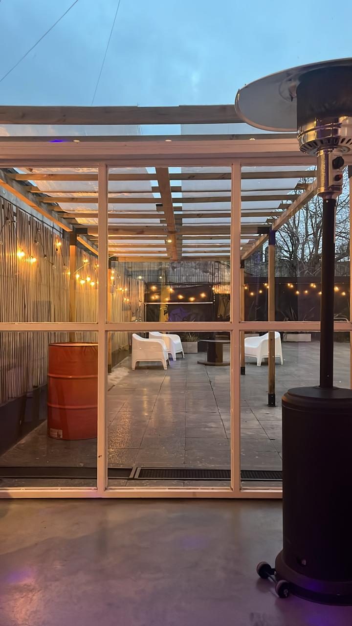 El patio con pérgola, guirnaldas de luces y estufa exterior